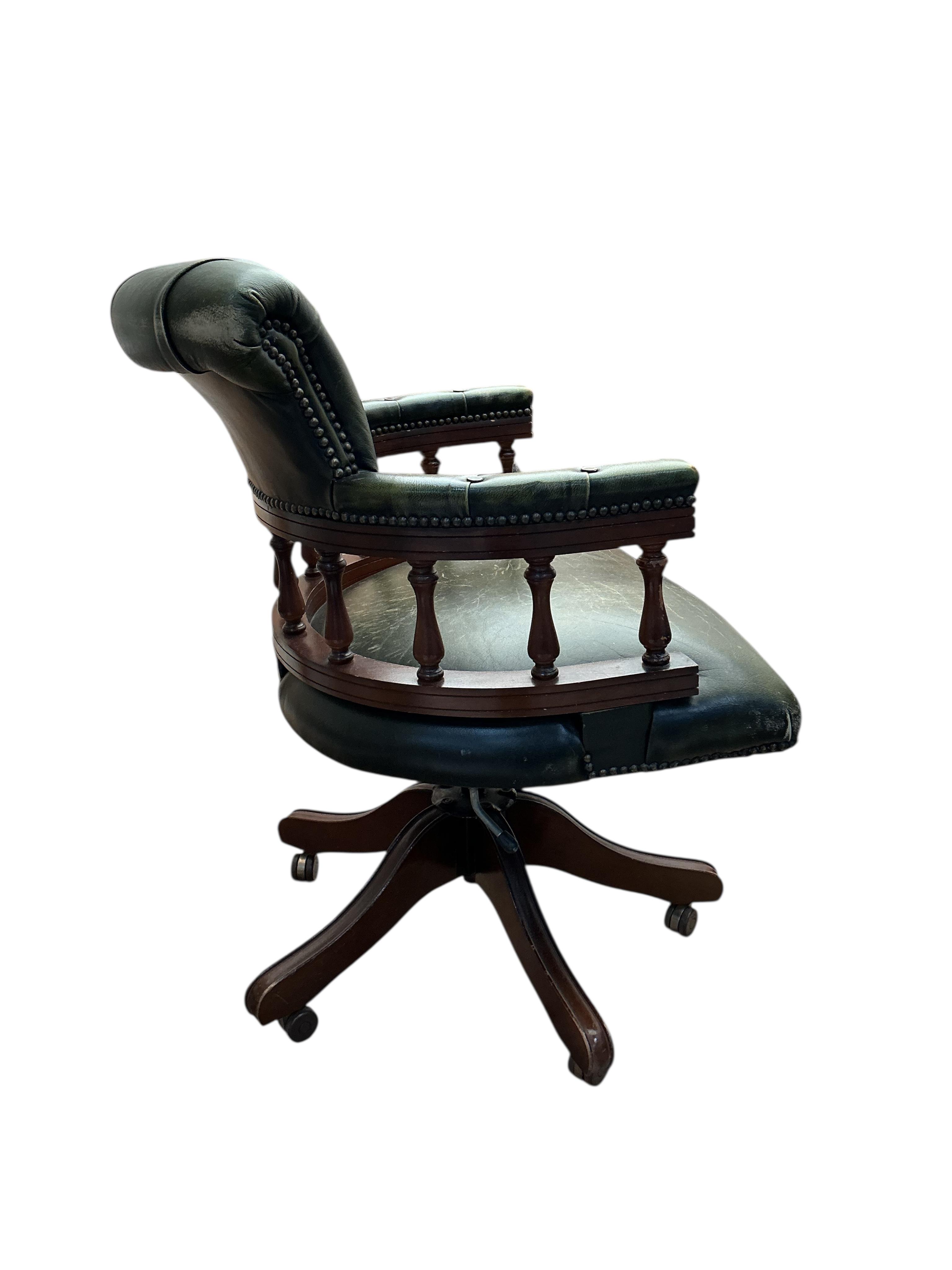 A reproduction buttoned green leather beech swivel desk chair, width 61cm, depth 54cm, height 88cm